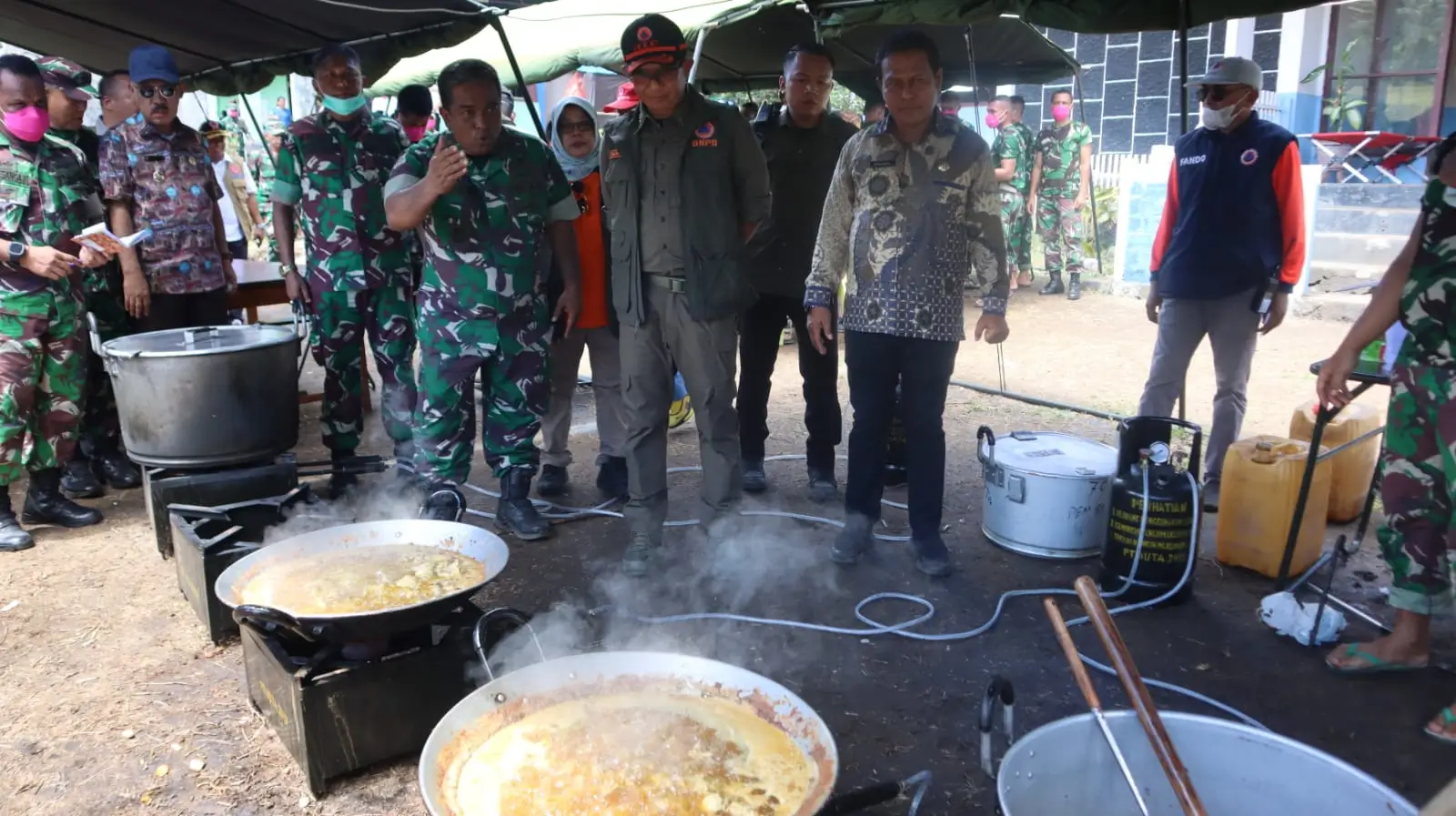 Kepala BNPB Letjen TNI Suharyanto, S. Sos., M.M (kemeja dan rompi hijau) saat mengunjungi pos dapur umum yang menyiapkan permakanan bagi pengungsi yang terdampak erupsi Gunungapi Ibu, di Kabupaten Halmahera Barat, Maluku Utara pada Kamis (30/5).